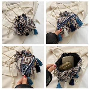 Detail of colorful geometric woven bucket bag with tassels and interior storage space