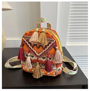 Close-up of ethnic woven mini backpack featuring multi-color tassels and patterned straps