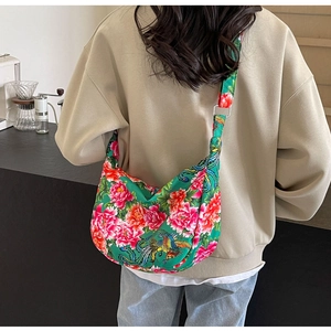 Detail of green floral canvas half-moon crossbody bag with traditional peony embroidery