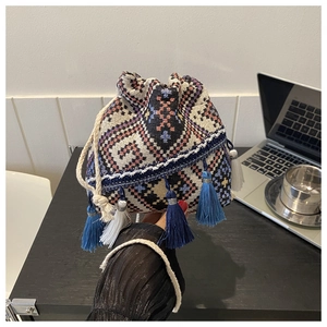 Detail of ethnic bucket bag with colorful tassel fringe and woven geometric patterns