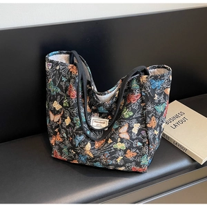 Detail of colorful butterfly embroidery and branded label on large canvas tote bag