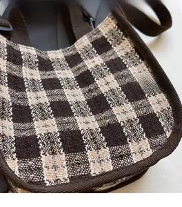 Close-up of the woven checkered fabric and texture details on the vintage shoulder bag