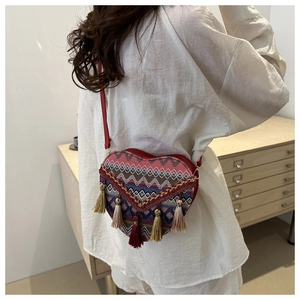 Detail of hand-woven heart bag with multi-color wave patterns and bohemian fringe decor