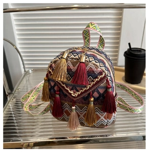 Detail of bohemian mini backpack featuring colorful jacquard fabric and long silk tassels