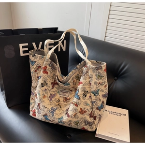 Detail of colorful butterfly patterns and woven label on a cream canvas tote bag