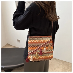 Détail du sac tissé bohème avec motifs géométriques colorés et longues franges pendantes