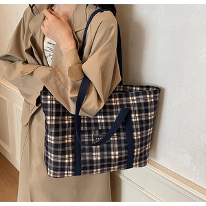 Détail du sac cabas à carreaux bleu marine et beige avec écusson fashion et anses