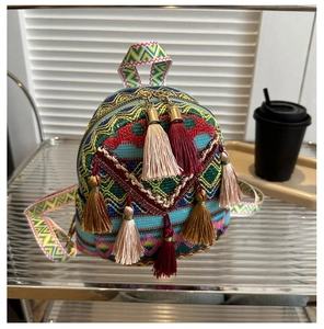 Detail of bohemian mini backpack with colorful woven patterns and decorative tassels
