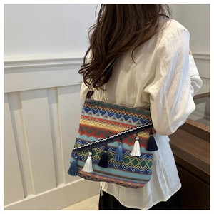 Détail d'un sac bandoulière bohème tissé main aux motifs ethniques géométriques et franges