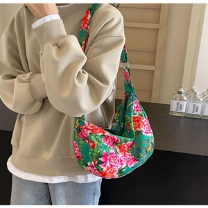 Detail of green hobo bag with traditional Chinese floral pattern and wide shoulder strap