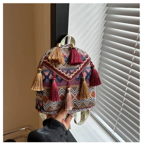 Detail of bohemian woven backpack with colorful geometric patterns and long tassels