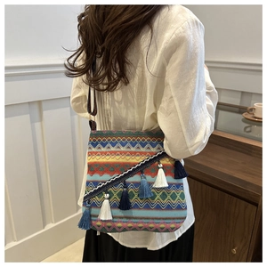 Détails du sac tissé bohème aux motifs géométriques et pompons bleus sur fond intérieur