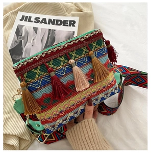 Close-up of bohemian woven bag with colorful fringe tassels and ethnic patterned strap