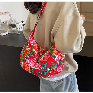 Detail view of large red canvas tote featuring traditional peony and phoenix embroidery