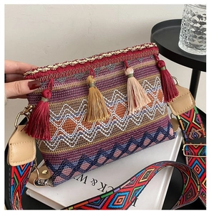 Detail of bohemian woven crossbody bag with ethnic patterns and colorful tassels