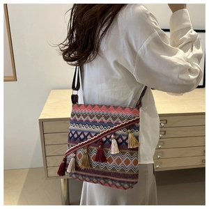 Détail d'un sac tissé bohème aux motifs de vagues colorés et longs glands décoratifs