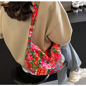 Detailed view of red oriental floral shoulder bag with phoenix pattern on model back