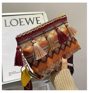 Detail of bohemian woven crossbody bag featuring colorful tassels and geometric jacquard strap