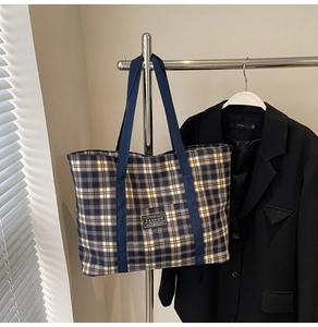 Détail du sac cabas à carreaux bleu et jaune avec étiquette mode et anses en toile