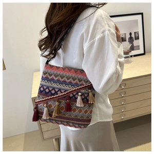 Détail du sac bandoulière bohème tissé avec glands colorés et bandoulière ethnique