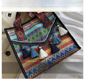 Detail of bohemian woven tote bag showing colorful geometric patterns and decorative tassels