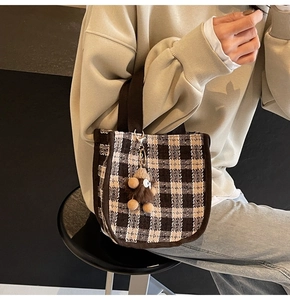 Fashionable brown checkered tote bag featuring a cute plush bear charm on a shoulder strap