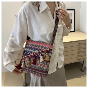 Détail du sac tissé bohème avec des motifs de vagues colorés et de longues franges