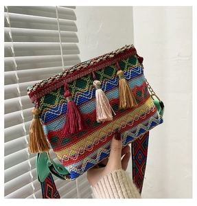Detail of colorful bohemian woven crossbody bag with vibrant fringes and wide ethnic strap
