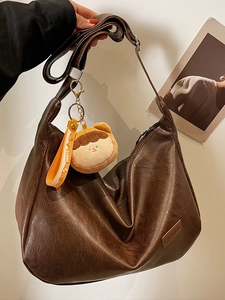 Large dark brown vintage hobo bag with plush doll pendant and leather fashion tag