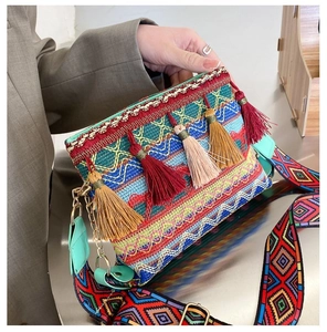 Detail of bohemian crossbody bag with colorful tassels and geometric jacquard strap