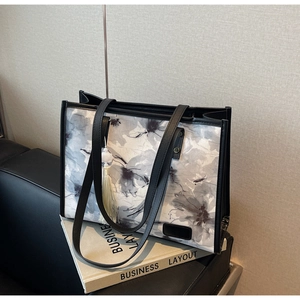 Détail du sac cabas à fleurs à l'encre avec lanières en cuir noir et élégant pompon en soie