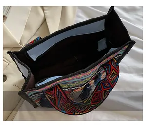 Internal view of ethnic tote bag with colorful tassels, zipper closure and blue lining