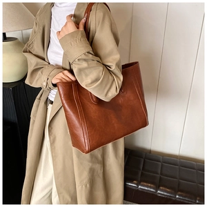 Detail of vintage brown tote bag showing durable PU leather texture and premium stitching