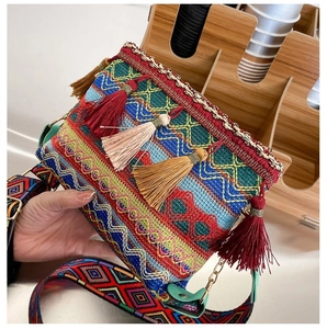 Detail of colorful woven bohemian bag with geometric patterns and fringe tassels