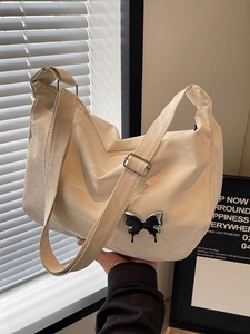 Sac à bandoulière crème avec texture marbrée et pendentif papillon en métal argenté