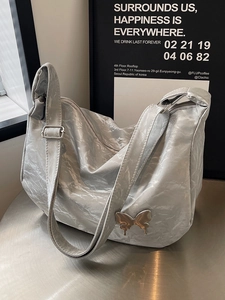 Sac hobo chic avec boucle papillon métallique et texture grise élégante
