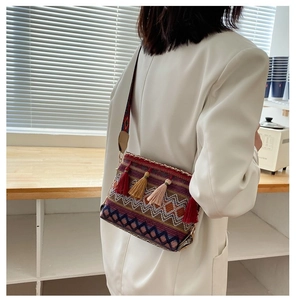 Close-up of bohemian shoulder bag with colorful fringe and woven patterns on a model