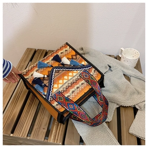 Detailed view of bohemian woven tote bag with colorful fringe and embroidered straps