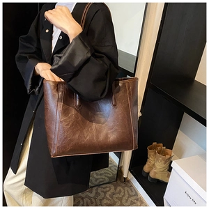 Detail of vintage brown tote bag with textured synthetic leather and large capacity