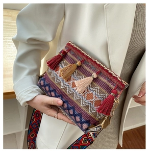 Detail of bohemian woven crossbody bag featuring colorful tassels and ethnic shoulder strap