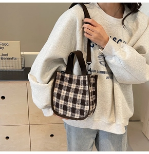 Detailed view of vintage checkered tweed handbag with brown woven handles and strap