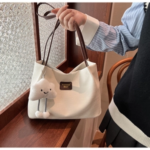 Dettaglio della borsa tote in velluto a coste bianco con tracolla e ciondolo nuvola