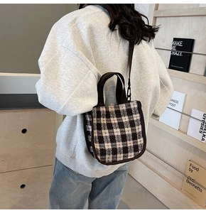 Detail of vintage plaid fabric handbag shown crossbody in a minimalist home setting