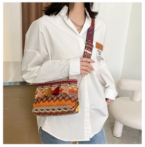 Ethnic style woven crossbody bag with colorful tassels and geometric patterned shoulder strap