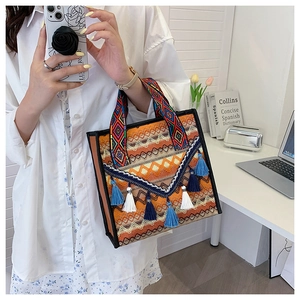 Detail of woven boho tote bag featuring colorful geometric patterns and multi-color tassels