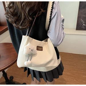 Dettaglio della borsa tote in velluto a coste bianco crema con ciondolo a nuvola