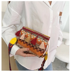 Detail of bohemian woven crossbody bag with colorful tassels and geometric patterns