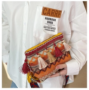 Close-up of Bohemian woven crossbody bag featuring colorful tassels and ethnic pattern strap