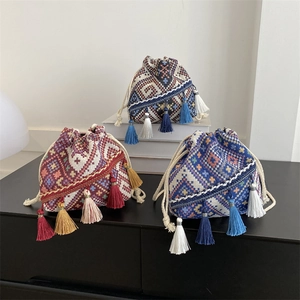 Bolso tipo cubo de estilo étnico bohemio con flecos de colores y diseño tejido