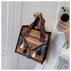 Detail of bohemian woven tote bag showing colorful fringe and geometric textures